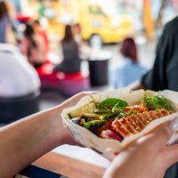 Hands,Holding,A,Paper,Container,Filled,With,Asian,Street,Food,